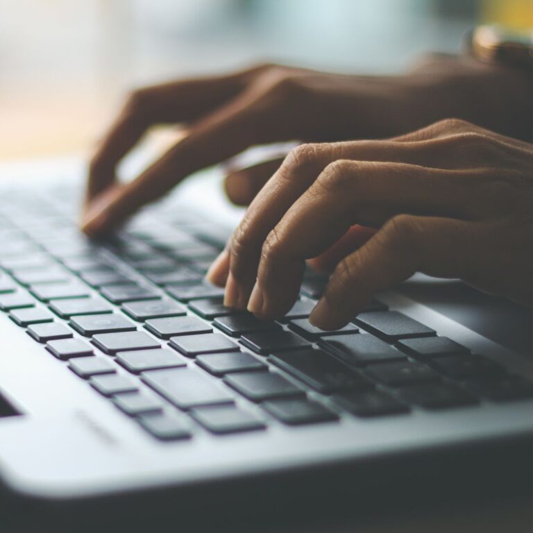 pair of hands typing on computer